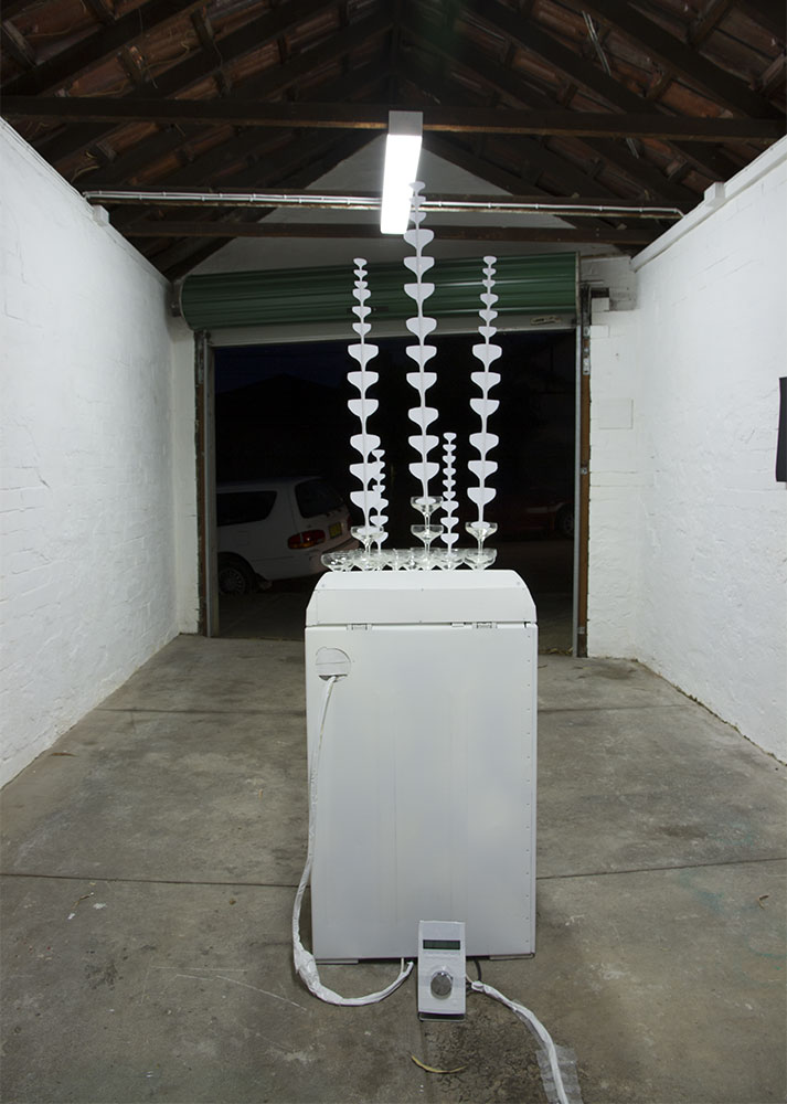 Josie Cavallaro: Spin, 2013. Washing machine, champagne glasses, sound, paper
