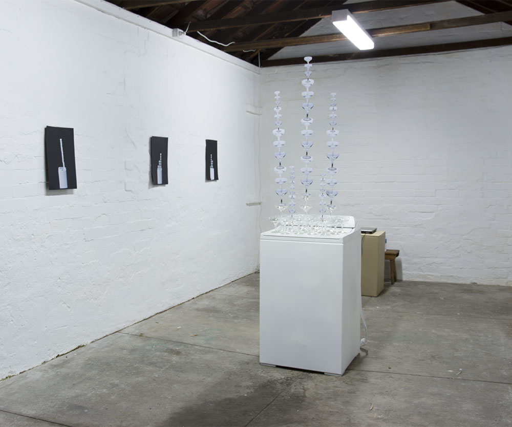 Josie Cavallaro: Spin, 2013. Washing machine, champagne glasses, sound, paper